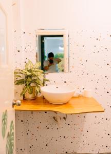 a person taking a picture of a bathroom with a sink at Hanoi Hola House in Hanoi