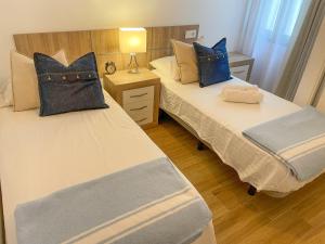 2 Betten mit blauen Kissen in einem Zimmer in der Unterkunft La Rosa Apartment Los Boliches Fuengirola Malaga Spain in Fuengirola
