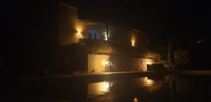 een gebouw 's nachts verlicht met een plas water bij Moderne Villa mit atemberaubendem Seeblick in Lisciano Niccone
