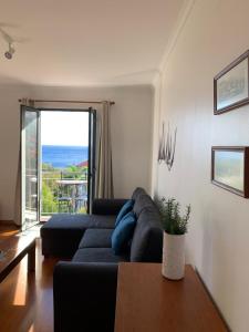 a living room with a blue couch and a table at Amazing SEA LIGHT Apartment, close to the beach. in Santa Cruz