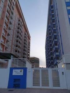 einen weißen Zaun vor einigen hohen Gebäuden in der Unterkunft Apartamento Mar de Oropesa ll in Oropesa del Mar