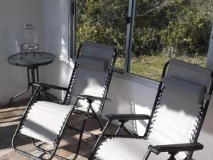 dwa krzesła i stół na ganku w obiekcie El Destacamento w mieście Villa Serrana