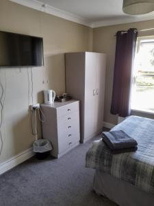 1 dormitorio con 1 cama, vestidor y TV en Black Bull Inn, en Immingham