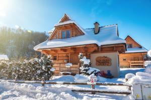 a log cabin in the snow with a fence at Domek Trzy Doliny Zakopane - Three Valleys Chalet Zakopane in Zakopane