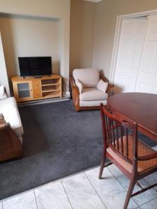 a living room with a tv and a chair and a table at Black Bull Inn in Immingham