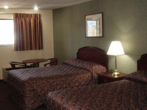 Habitación de hotel con 2 camas y mesa en German Village Inn Motel, en Columbus
