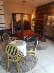 een slaapkamer met een bed met een tafel en stoelen bij Apartament Loft in Radom