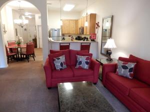 a living room with two red couches and a kitchen at Bahama Bay in Kissimmee