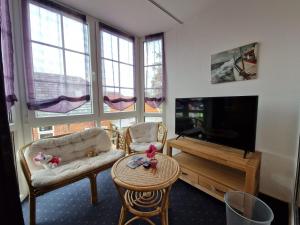 a living room with a tv and a couch and a table at Ferienhaus Backbord im Bootshaus in Neßmersiel