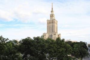 a tall clock tower towering over a city at Premium Key-Apartaments Śródmieście in Warsaw