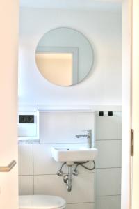 La salle de bains est pourvue d'un lavabo et d'un miroir. dans l'établissement The Manhattan A Boutique Hotel By American Ease, à Grafenwöhr