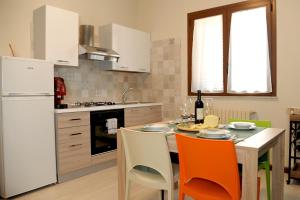 Una cocina con una mesa y un refrigerador blanco. en Etnasentieri Wine house on Etna mount, en Belpasso