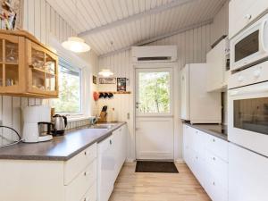 a kitchen with white cabinets and a window at 8 person holiday home in Roslev in Glyngøre