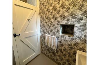 a bathroom with a white door and a towel at Roberts Yard Country Cottage in Kilkenny