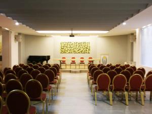 アヴェルサにあるHotel del Sole-Aversaの椅子とピアノが置かれた空き部屋