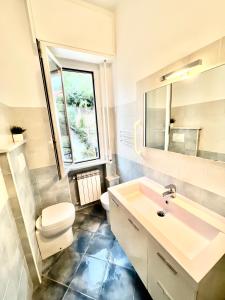 La salle de bains est pourvue d'un lavabo, de toilettes et d'une fenêtre. dans l'établissement A 5 minuti dal mare - Dolphin Beach House, à Spotorno
