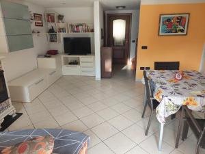 a living room with a table and a television at Maison Magicien in Oyace