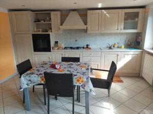 a kitchen with a table with a flowery table cloth at Maison Magicien in Oyace