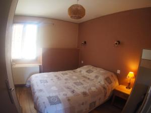 um pequeno quarto com uma cama e uma janela em Le petit coin au bord du lac em Doussard