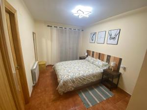 a small bedroom with a bed and a night stand at Casa La Fontana Bronchales in Bronchales