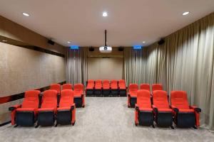una sala de conferencias con sillas y cortinas rojas en Conezion Luxury at IOI Mall Putrajaya, en Putrajaya
