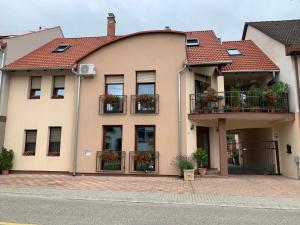 a building with windows and balconies with flowers on them at Fodan Apartman in Sárvár