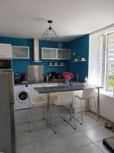cocina con paredes azules, mesa y sillas en Studio entre Clohars Carnoet et Doelan en Clohars-Carnoët