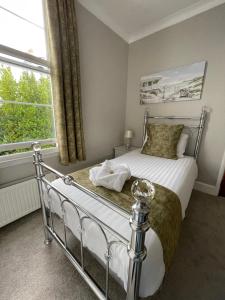 a bedroom with a bed and a large window at Glenorleigh in Torquay