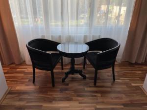 a table and two chairs and a glass table and chairs at M & I Apartment 3 in Târgu-Mureş