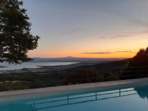 een zwembad met uitzicht op de oceaan bij zonsondergang bij Moderne Villa mit atemberaubendem Seeblick in Lisciano Niccone +47 foto's