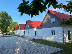 Une rangée de maisons avec des toits rouges dans une rue dans l'établissement Holiday home on the island of Poel, 3 bedrooms, 2 bathrooms, sauna, à Poel