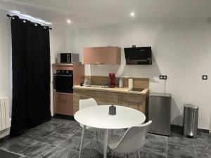 a small kitchen with a white table and chairs at Joli appartement in Blanzy
