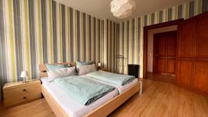 a bedroom with a bed in a room with striped walls at Ferienwohnung am Bodetal mit Wallbox für E-Auto in Thale +13 photos