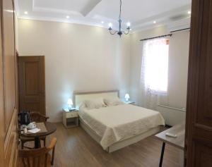 a bedroom with a bed and a table and a chair at Chola Guest House in Bitola