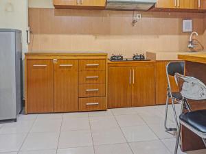 a kitchen with wooden cabinets and a counter top at Capital O 91820 S&a Collection 2 in Jakarta