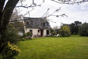 une maison blanche avec une cour agrémentée d'une pelouse verte dans l'établissement Les Hortensias, Maison 8 personnes, proche mer, Le Pouldu, à Clohars-Carnoët