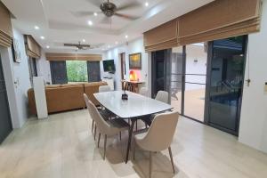 a dining room and living room with a table and chairs at Lovely modern 2 bed villa in Pran Buri