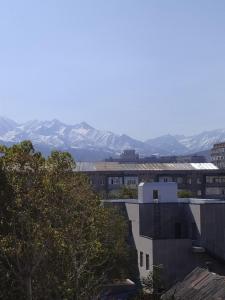 a view of a city with mountains in the background at AURA on Gogol street 28a in Bishkek