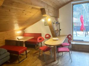 jadalnia ze stołem i czerwonymi krzesłami w obiekcie Gästehaus Katharina w mieście Hochfilzen