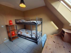 Cette chambre comprend 2 lits superposés et une table. dans l'établissement Vakantiehuis in Knokke-Heist met tuin en parkeerplaats, à Knokke-Heist