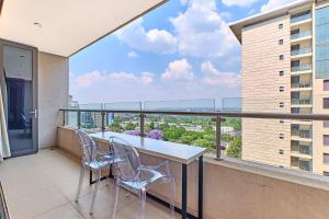Un balcón con 2 sillas y una mesa con vistas. en La Vista Dream Apartments Luxury & Modern with City View and Inverter back up!, en Johannesburgo