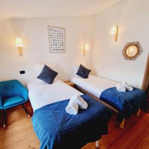 Pokój z 2 łóżkami i niebieskim krzesłem w obiekcie ALPES IV - Hyper Centre - Parking - 40m² w Chamonix-Mont-Blanc