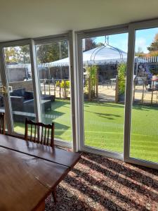 a screened in porch with a wooden table and windows at Black Bull Inn in Immingham