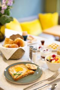 uma mesa com um prato com um ovo e uma tigela de comida em Hotel Louison em Paris