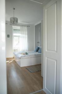um quarto branco com uma cama e uma janela em Apartmani 64 em Sombor
