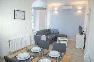 a living room with a table and chairs and a couch at Apartmani 64 in Sombor
