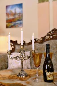 a table with two candles and a bottle of wine at Luxusní apartmán s empírovými freskami v centru Čáslavi in Čáslav