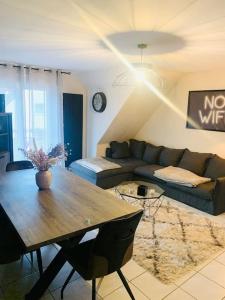ein Wohnzimmer mit einem Tisch und einem Sofa in der Unterkunft Charmant appartement 2 pièces Mundolsheim in Mundolsheim