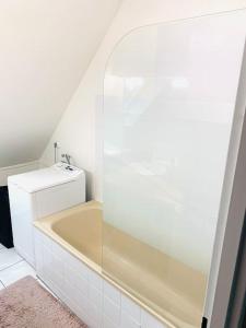 ein Badezimmer mit einer Badewanne und einem Waschbecken in der Unterkunft Charmant appartement 2 pièces Mundolsheim in Mundolsheim