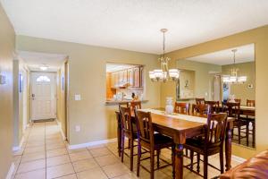 een eetkamer en keuken met een tafel en stoelen bij Ocean view condo in beachfront resort with WiFi, central AC, 2 pools, & tennis in St. Augustine